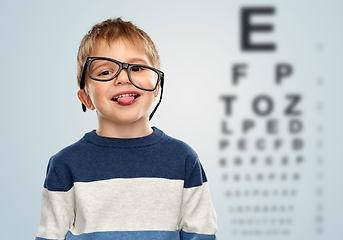 Image showing little boy in glasses showing tongue