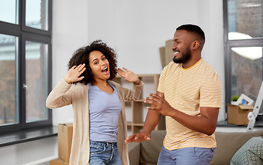 Image showing happy couple moving to new home and dancing