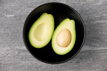Image showing close up of ripe avocado with bone in ceramic bowl