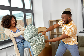 Image showing happy couple having pillow fight at new home