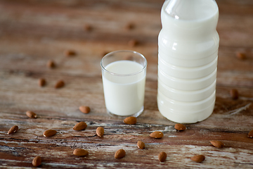 Image showing milk and almonds on wooden table