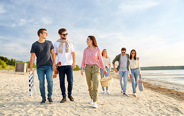 Image showing happy friends walking along summer beach