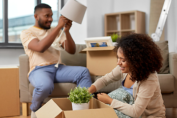 Image showing happy couple packing boxes and moving to new home