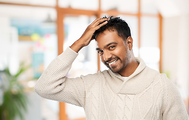 Image showing indian man in knitted sweater touching his hair