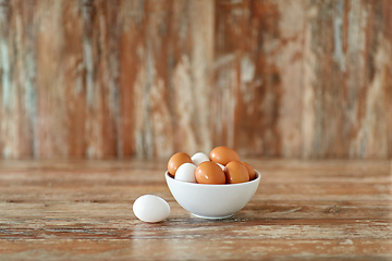 Image showing close up of eggs in ceramic bowl on wooden table