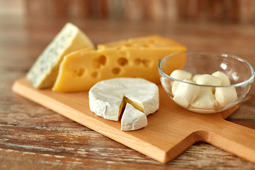 Image showing different kinds of cheese on wooden cutting board