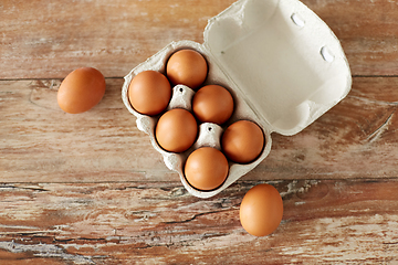 Image showing close up of eggs in cardboard box on wooden table