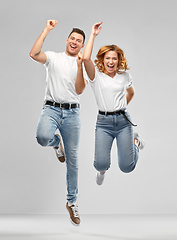 Image showing happy couple in white t-shirts jumping