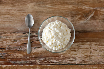 Image showing close up of cottage cheese in bowl on wooden table