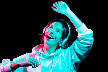 Image showing woman in headphones listening to music and dancing