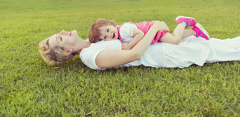 Image showing mother and little daughter playing at backyard