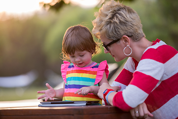 Image showing mom and her little daughter using tablet computer