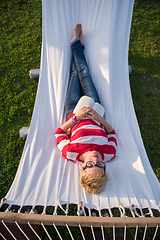 Image showing woman reading a book while relaxing on hammock