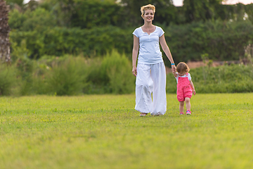 Image showing mother and little daughter playing at backyard