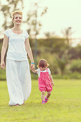 Image showing mother and little daughter playing at backyard