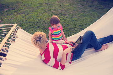 Image showing mom and a little daughter relaxing in a hammock