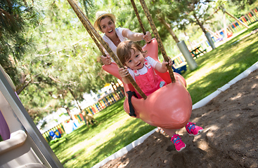 Image showing mother and daughter swinging in the park