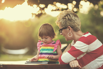 Image showing mom and her little daughter using tablet computer