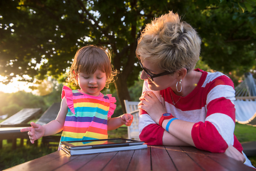 Image showing mom and her little daughter using tablet computer