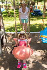 Image showing mother and daughter swinging in the park