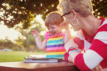 Image showing mom and her little daughter using tablet computer