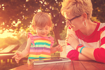 Image showing mom and her little daughter using tablet computer