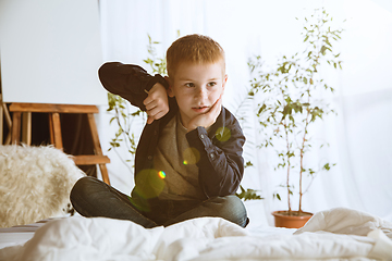 Image showing Little boy using different gadgets at home