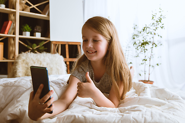 Image showing Little girl using different gadgets at home