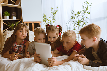 Image showing Little boys and girls using different gadgets at home