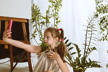 Image showing Little girl using different gadgets at home