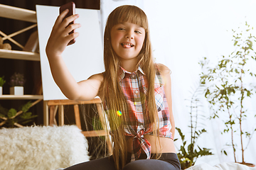 Image showing Little girl using different gadgets at home