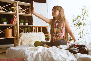 Image showing Little girl using different gadgets at home
