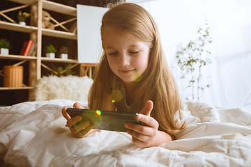 Image showing Little girl using different gadgets at home