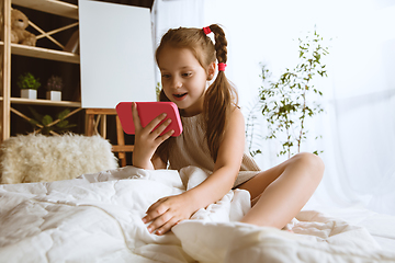 Image showing Little girl using different gadgets at home