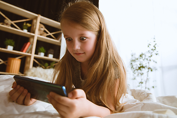 Image showing Little girl using different gadgets at home