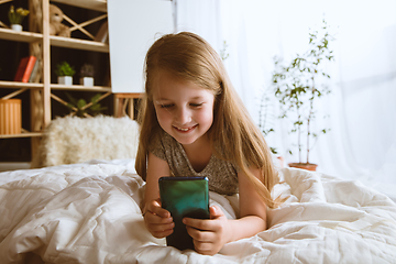 Image showing Little girl using different gadgets at home