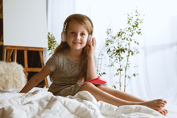 Image showing Little girl using different gadgets at home