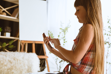 Image showing Little girl using different gadgets at home