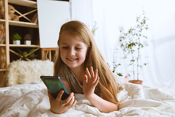 Image showing Little girl using different gadgets at home