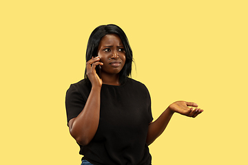 Image showing Young african woman isolated on yellow studio background, facial expression