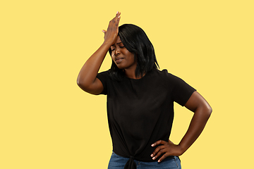 Image showing Young african woman isolated on yellow studio background, facial expression