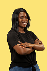 Image showing Young african woman isolated on yellow studio background, facial expression