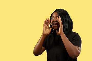 Image showing Young african woman isolated on yellow studio background, facial expression