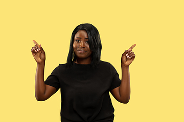 Image showing Young african woman isolated on yellow studio background, facial expression