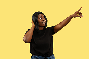 Image showing Young african woman isolated on yellow studio background, facial expression