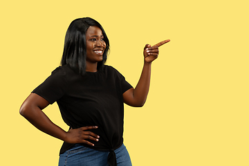 Image showing Young african woman isolated on yellow studio background, facial expression