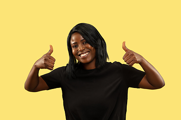 Image showing Young african woman isolated on yellow studio background, facial expression