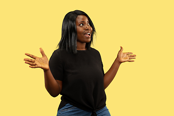 Image showing Young african woman isolated on yellow studio background, facial expression