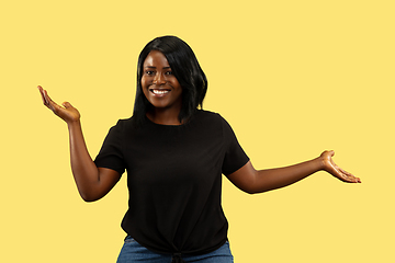 Image showing Young african woman isolated on yellow studio background, facial expression