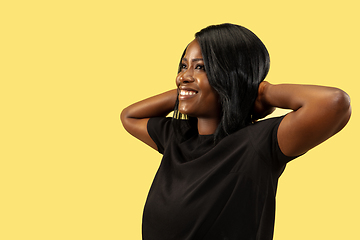 Image showing Young african woman isolated on yellow studio background, facial expression